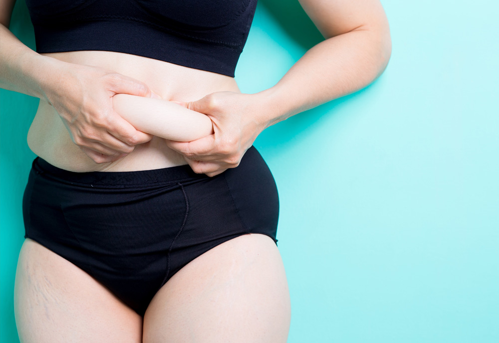 Photo of girl holding her belly fat